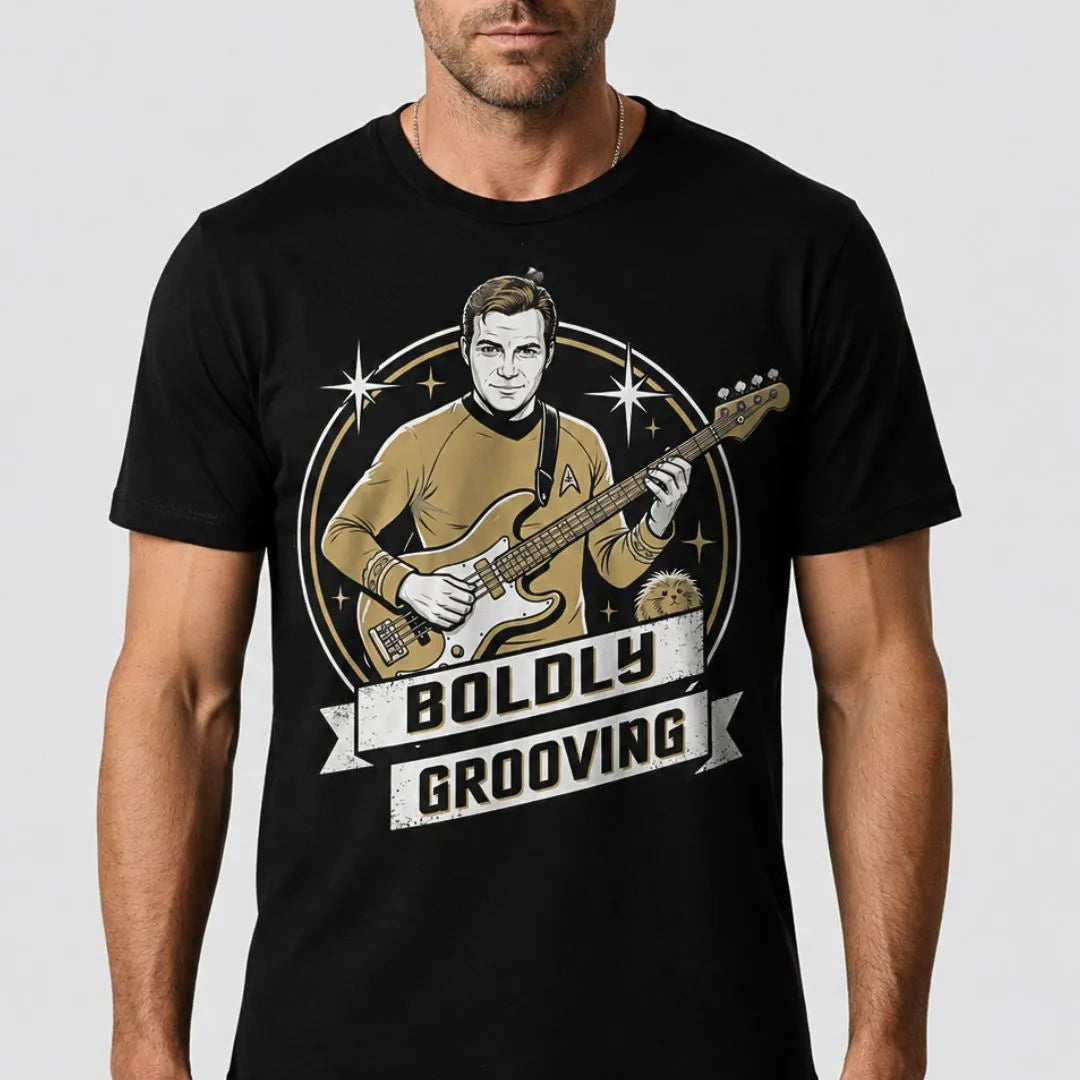 A man wearing a black crew-neck t-shirt with a graphic print of a man in a gold Star Trek uniform playing an electric bass guitar, with the text 'BOLDLY GROOVING' on a banner below.